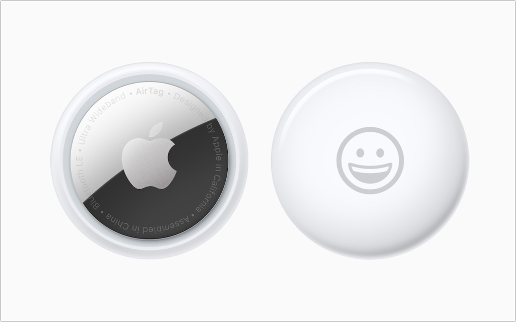 Two Apple AirTags on a white background; one shows the Apple logo and product info, while the other displays a simple smiling face icon.