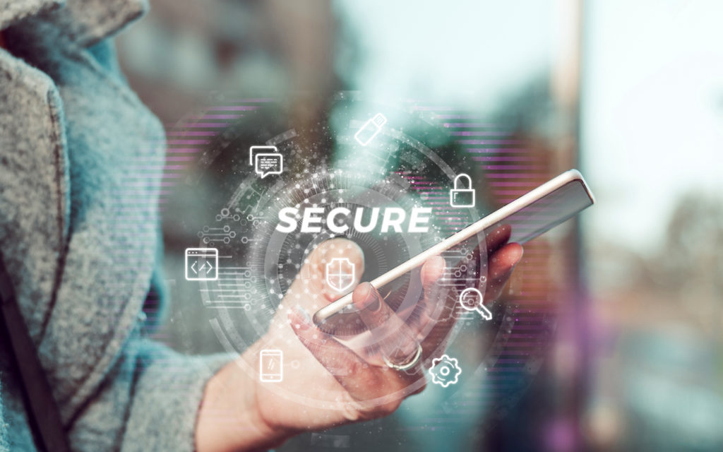 A person holding a smartphone with the word SECURE and security icons, such as locks and shields, overlaid digitally, representing mobile device security and data protection.