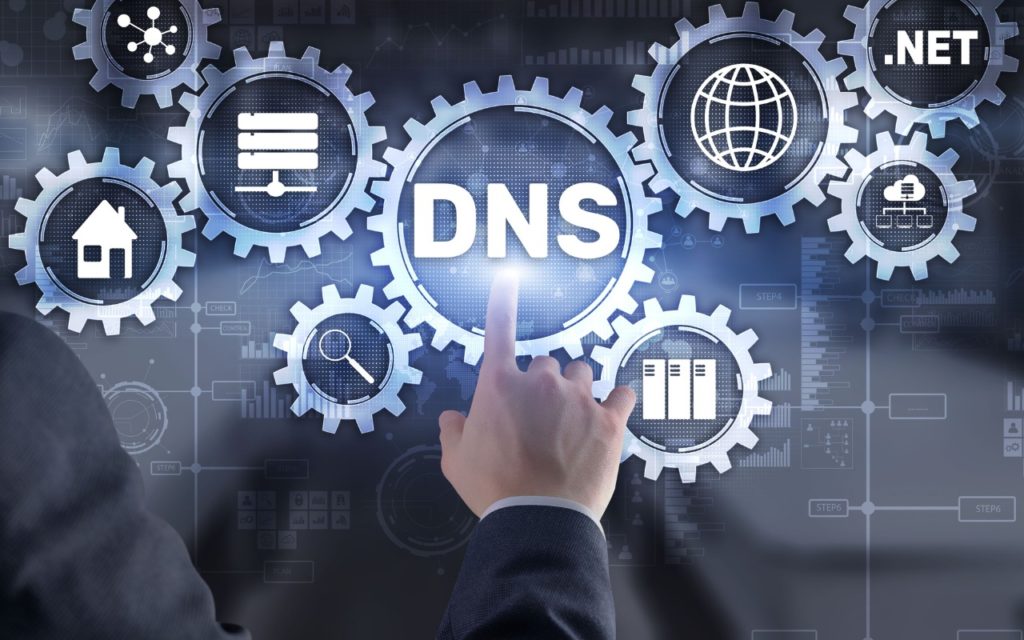 A person’s hand points to a glowing gear labeled DNS, surrounded by other gears showing icons for networking, internet, search, server, and the text .NET, symbolizing digital connectivity and DNS technology.