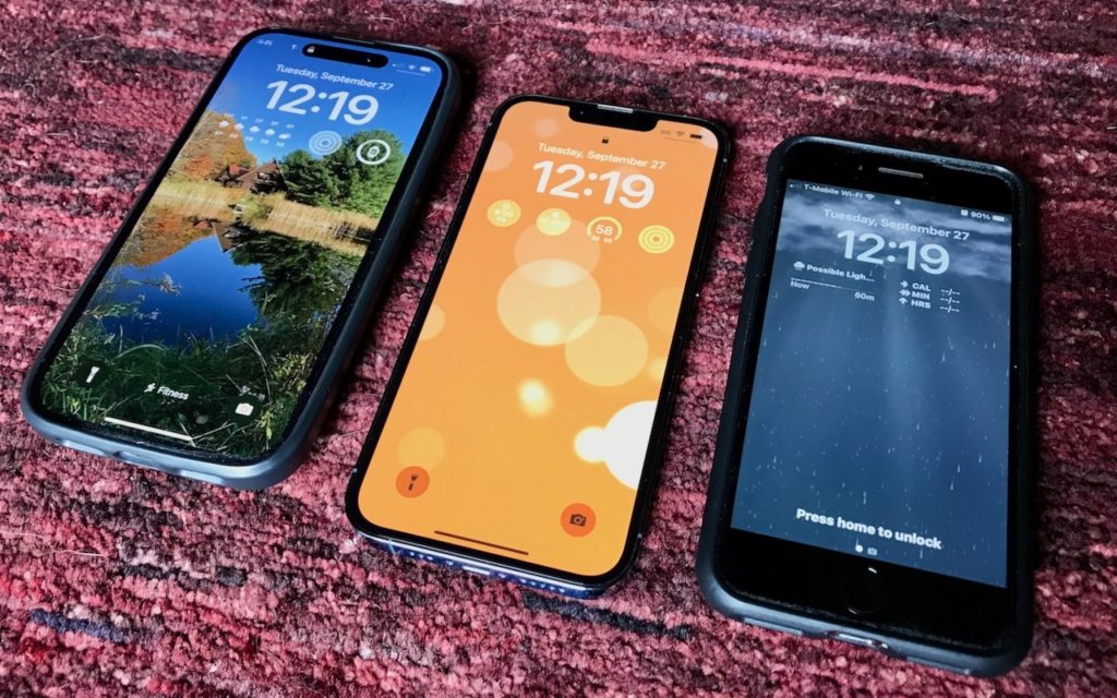 Three smartphones displaying different lock screens are placed side by side on a red textured surface. The time on all screens is 12:19, with varied wallpapers and notifications visible.