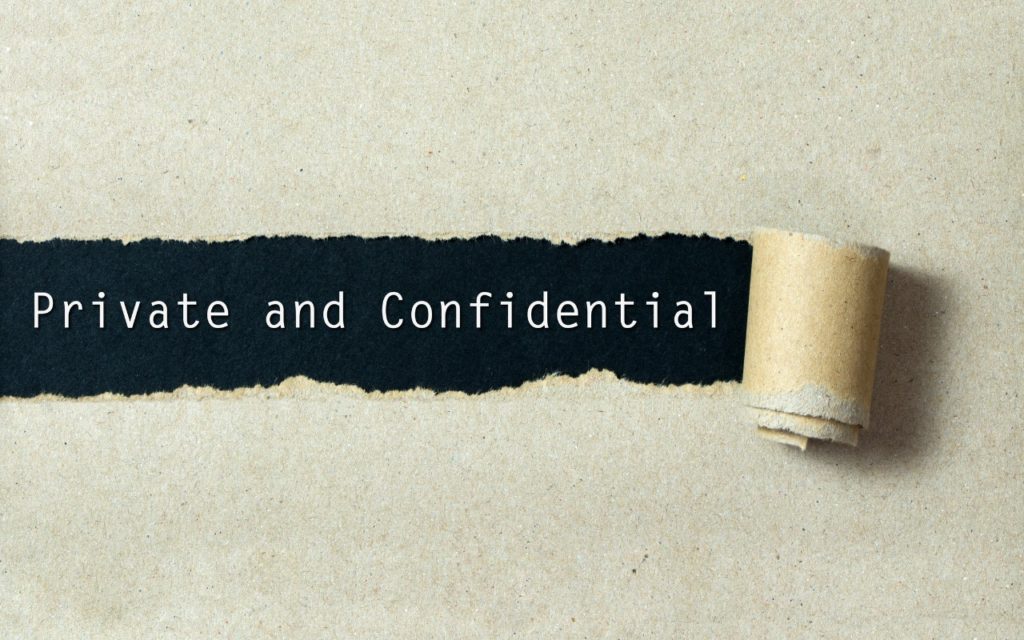 A torn strip of brown paper reveals the words Private and Confidential printed on a black background underneath.
