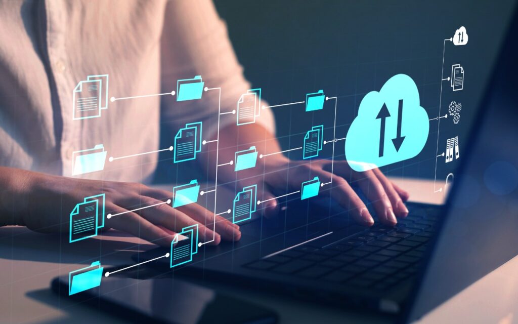 A person types on a laptop with digital icons of folders and a cloud, symbolizing cloud computing and data file transfer or sharing.