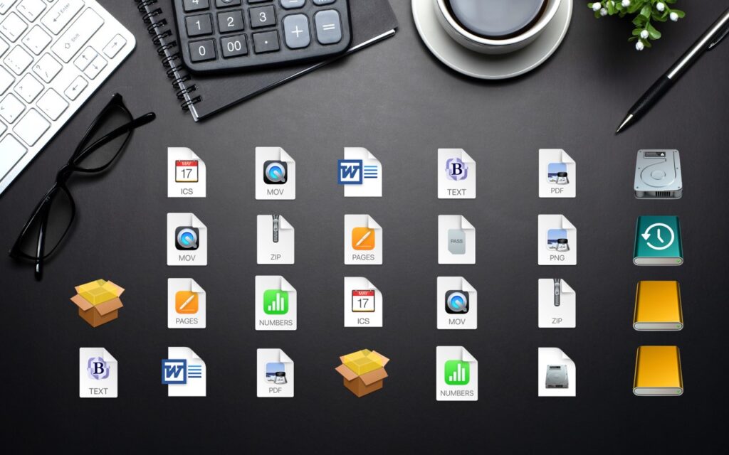 A black desk with a keyboard, glasses, calculator, notebook, pen, coffee cup, plant, and many digital file icons, including documents, images, compressed files, and drives, arranged neatly in rows.