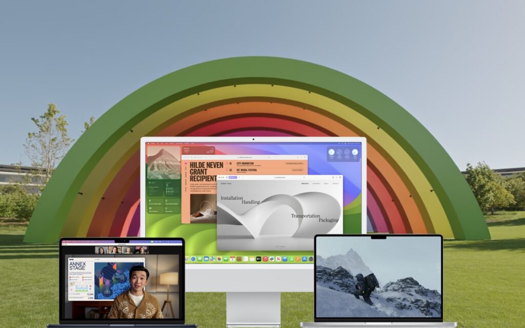 Three Apple devices—a MacBook, iMac, and MacBook Pro—displaying different screens, are set in front of a colorful, large rainbow arch outdoors on a sunny day with green grass and trees.
