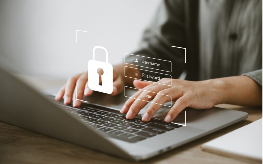 Hands typing on a laptop keyboard with a virtual login overlay showing username and password fields, urging users to Update Passwords on Compromised Sites after the “Mother of All Breaches” for enhanced online security.