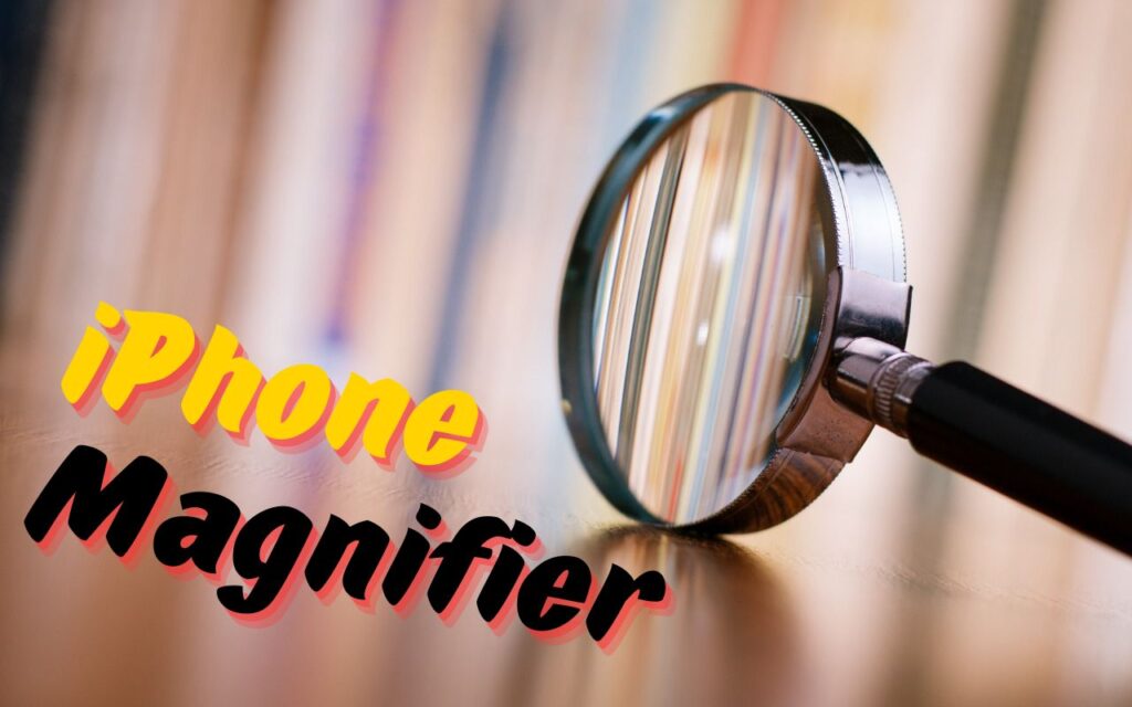 A magnifying glass lies on a wooden surface with blurred books in the background. Text on the left reads iPhone Magnifier in bold, colorful font—remember the Magnifier App when you need to read tiny text.