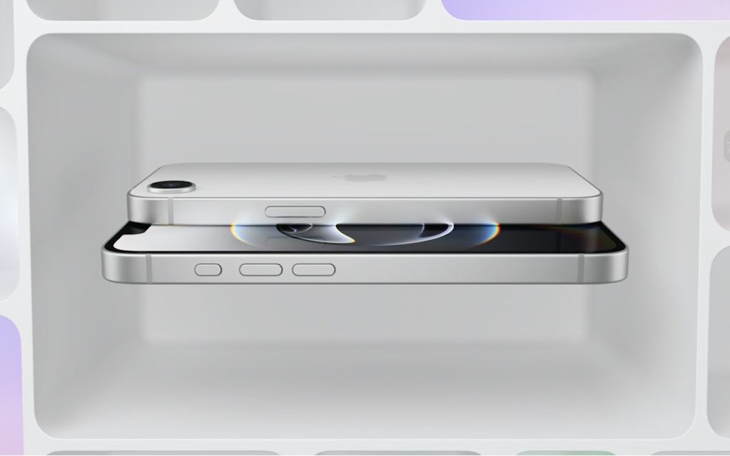 Two silver iPhones, including the new iPhone 16e that redefines budget iPhone choices, are stacked horizontally in a white, softly lit box; one displays its screen while the other reveals its camera lens and side buttons.