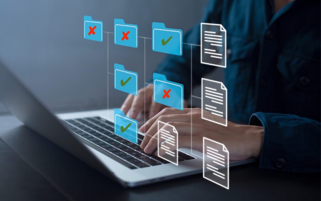 Hands typing on a laptop keyboard with virtual folders and documents displayed, showing green check marks and red Xs—highlighting file organization, sorting, and illustrating why you should Never Save Your Work in These Locations.