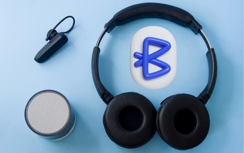 Black wireless headphones, a small round portable speaker, a Bluetooth earpiece, and a Bluetooth symbol are arranged on a light blue background. Did you know you can rename many Bluetooth devices for easier identification?.