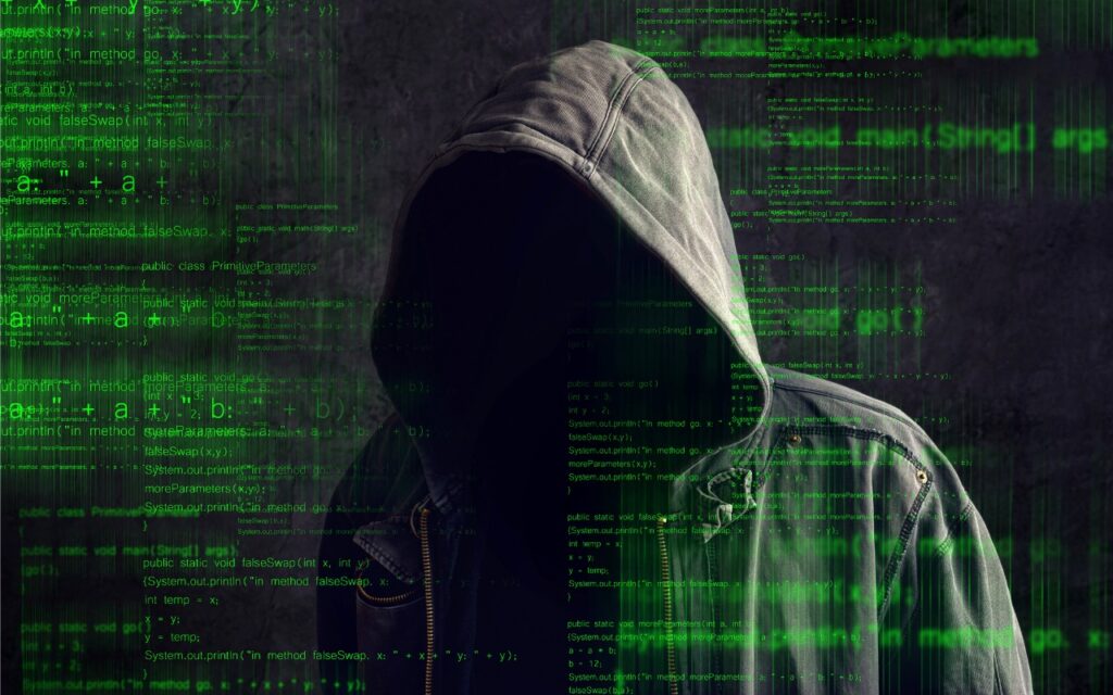 A person in a hooded jacket stands before a dark background, their face hidden in shadow. Transparent green code hints at hacking, alongside a warning: Never Paste Unknown Text into Terminal!—a nod to the most dangerous terminal commands for Mac.