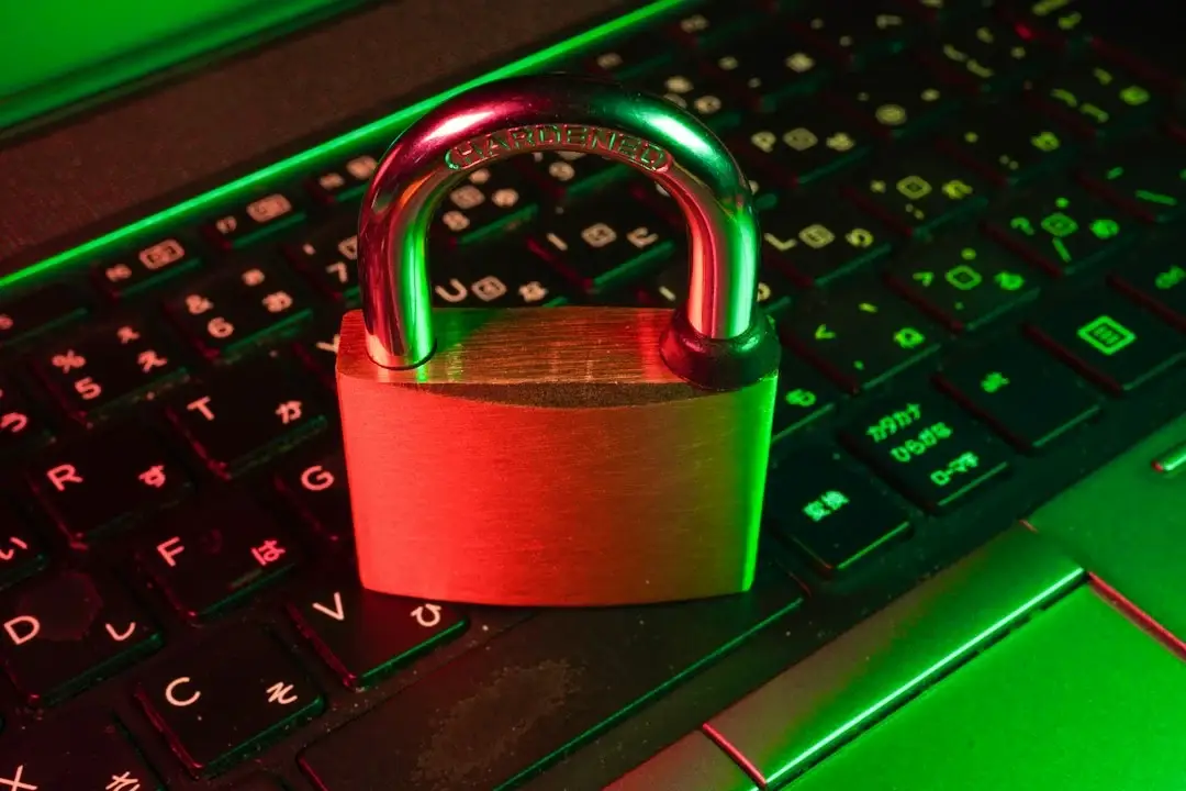 Red padlock on a black computer keyboard, representing cyber insurance IT security requirements